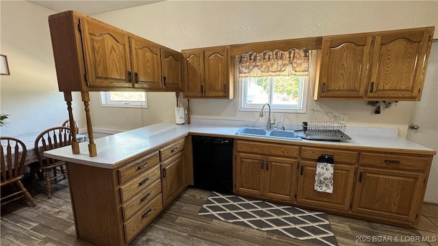 18997 Mystical Ln, Versailles, MO 65084 - kitchen with black dishwasher, a peninsula, brown cabinetry, and light countertops
