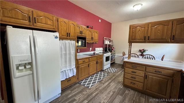 18997 Mystical Ln, Versailles, MO 65084 - kitchen featuring white appliances, dark wood-type flooring, a textured ceiling, brown cabinetry, and light countertops