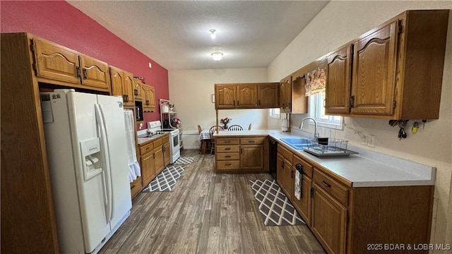 18997 Mystical Ln, Versailles, MO 65084 - kitchen with white appliances, dark wood-style flooring, light countertops, brown cabinetry, and a textured ceiling