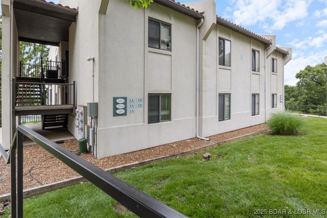 33 Monterey Dr Unit 2A, Lake Ozark, MO 65049 - view of side of home featuring stucco siding and a lawn