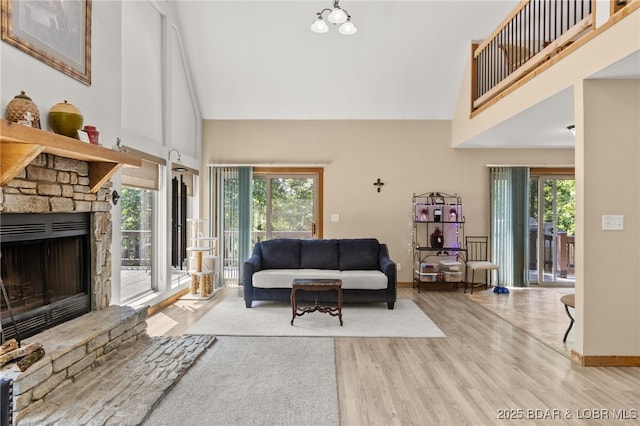 28 Hamilton Way, Sunrise Beach, MO 65079 - living room featuring high vaulted ceiling, wood finished floors, healthy amount of natural light, and a fireplace