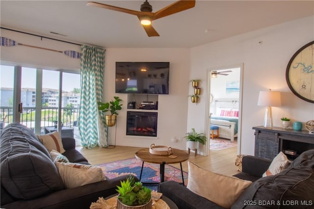 418 Regatta Bay Dr Unit 4A, Lake Ozark, MO 65049 - living room featuring a ceiling fan, wood finished floors, and a glass covered fireplace