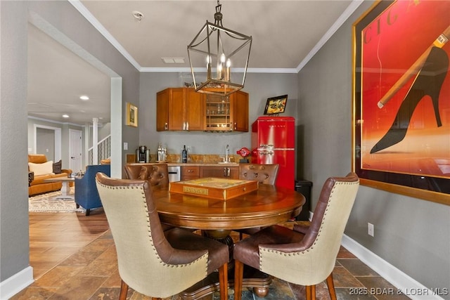 7 Lost Spike Ct, Camdenton, MO 65020 - dining space featuring ornamental molding, stone tile floors, a chandelier, and bar