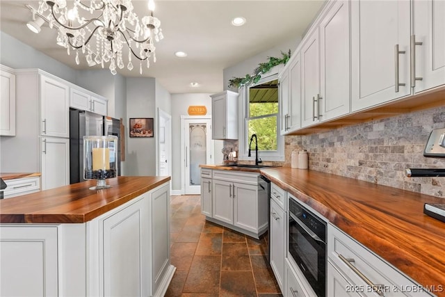 7 Lost Spike Ct, Camdenton, MO 65020 - kitchen with wooden counters, appliances with stainless steel finishes, a chandelier, decorative backsplash, and recessed lighting