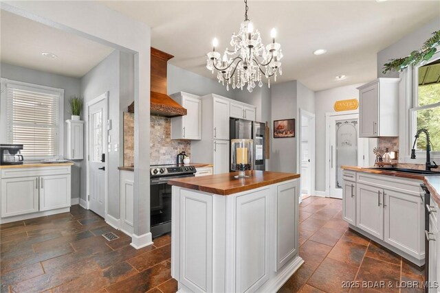 7 Lost Spike Ct, Camdenton, MO 65020 - kitchen featuring wooden counters, appliances with stainless steel finishes, backsplash, a chandelier, and a kitchen island