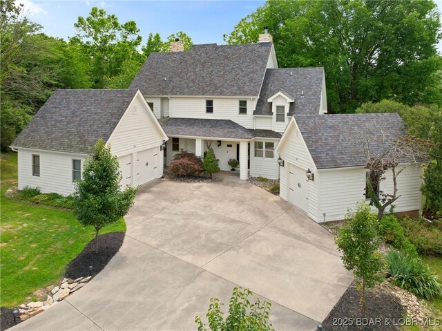 7 Lost Spike Ct, Camdenton, MO 65020 - traditional-style house featuring an attached garage, driveway, a chimney, and a front yard