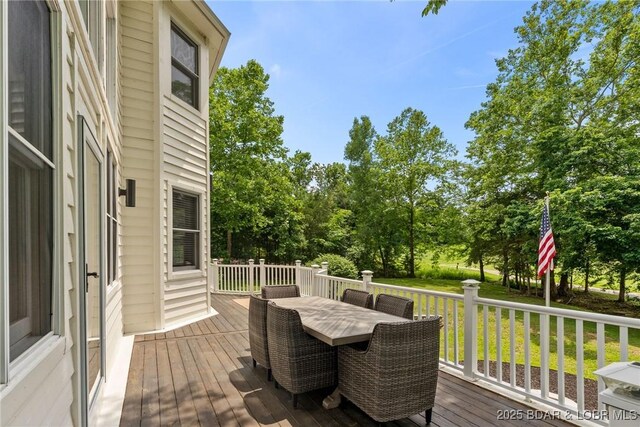 7 Lost Spike Ct, Camdenton, MO 65020 - wooden terrace with outdoor dining area, a lawn, and view of scattered trees