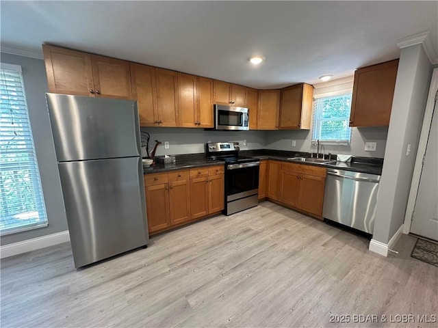 20 Barba Le Ln, Lake Ozark, MO 65049 - kitchen featuring stainless steel appliances, light wood-style floors, dark countertops, brown cabinets, and crown molding