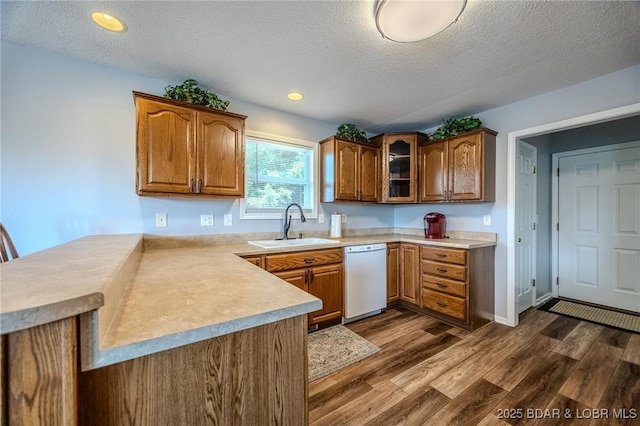 1508 Purvis Rd, Sunrise Beach, MO 65079 - kitchen featuring dishwasher, a peninsula, light countertops, dark wood-style floors, and brown cabinetry
