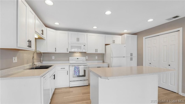 150 Southwood Shores Dr Unit 71-1B, Lake Ozark, MO 65049 - kitchen with white appliances, light wood-type flooring, light countertops, a kitchen island, and recessed lighting