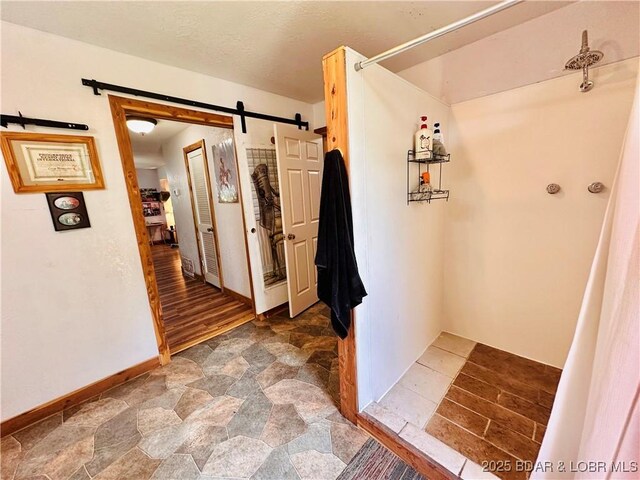 25372 Loon Blvd, Warsaw, MO 65355 - hallway featuring a barn door and stone finish flooring