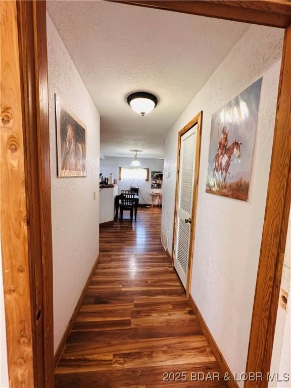 25372 Loon Blvd, Warsaw, MO 65355 - hallway featuring wood finished floors, a textured ceiling, and a textured wall