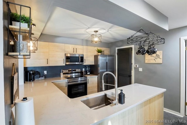 5940 Baydy Peak Rd Unit 1232, Osage Beach, MO 65065 - kitchen with appliances with stainless steel finishes, light brown cabinetry, light countertops, and a peninsula