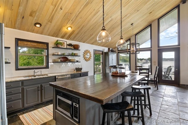 30594 Johnson Bay Rd, Gravois Mills, MO 65037 - kitchen featuring stainless steel appliances, wood ceiling, gray cabinetry, backsplash, and a kitchen bar