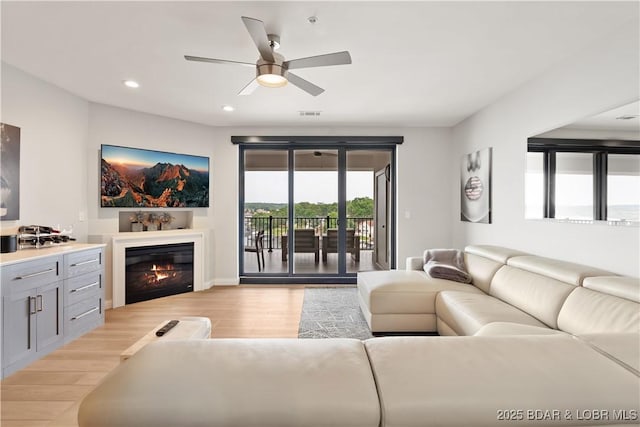 166 Captiva Dr Unit 5D, Sunrise Beach, MO 65079 - living area with light wood-style floors, a glass covered fireplace, ceiling fan, and recessed lighting