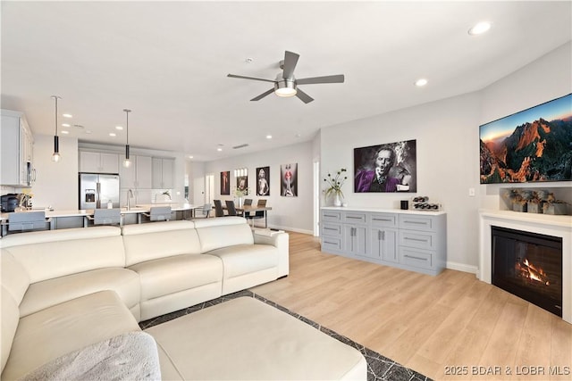 166 Captiva Dr Unit 5D, Sunrise Beach, MO 65079 - living area featuring a ceiling fan, light wood-style flooring, recessed lighting, and a glass covered fireplace