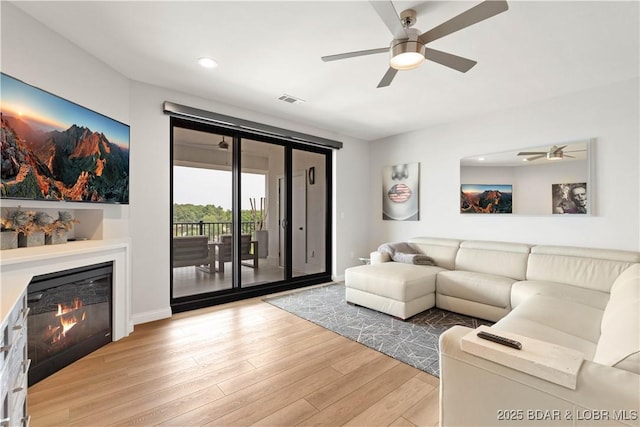 166 Captiva Dr Unit 5D, Sunrise Beach, MO 65079 - living room featuring ceiling fan, light wood finished floors, a glass covered fireplace, and recessed lighting
