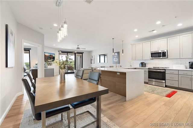 166 Captiva Dr Unit 5D, Sunrise Beach, MO 65079 - kitchen with appliances with stainless steel finishes, light wood-style flooring, light countertops, backsplash, and recessed lighting