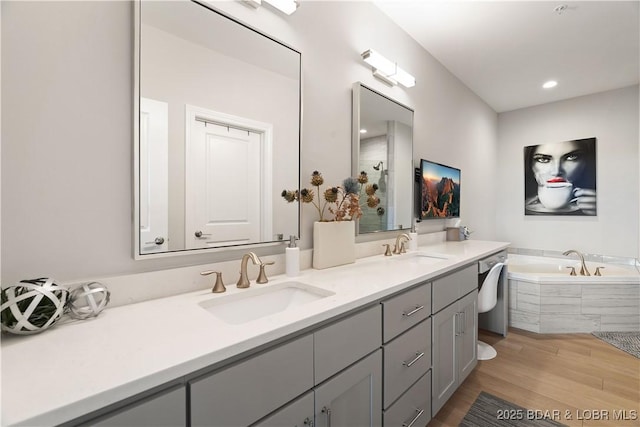 166 Captiva Dr Unit 5D, Sunrise Beach, MO 65079 - bathroom featuring double vanity, a garden tub, wood finished floors, and recessed lighting