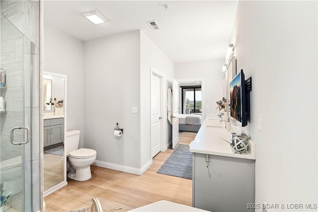 166 Captiva Dr Unit 5D, Sunrise Beach, MO 65079 - bathroom featuring wood finished floors, vanity, a stall shower, and ensuite bath