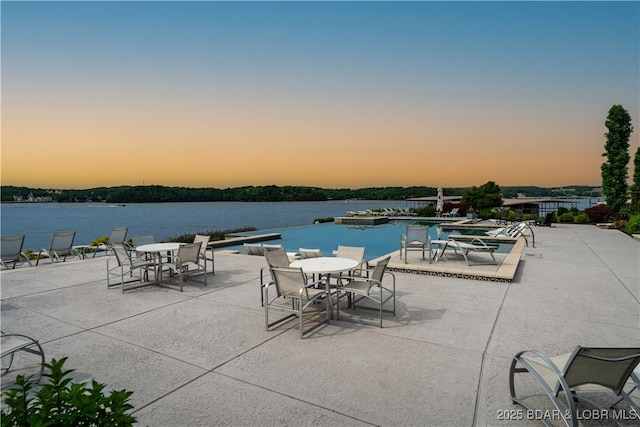 166 Captiva Dr Unit 5D, Sunrise Beach, MO 65079 - patio terrace at dusk with a patio, a water view, outdoor dining area, and a community pool