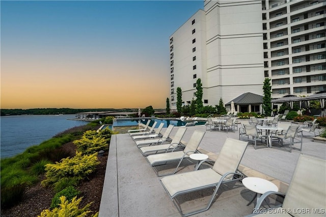 166 Captiva Dr Unit 5D, Sunrise Beach, MO 65079 - patio terrace at dusk featuring a water view, a community pool, and a patio