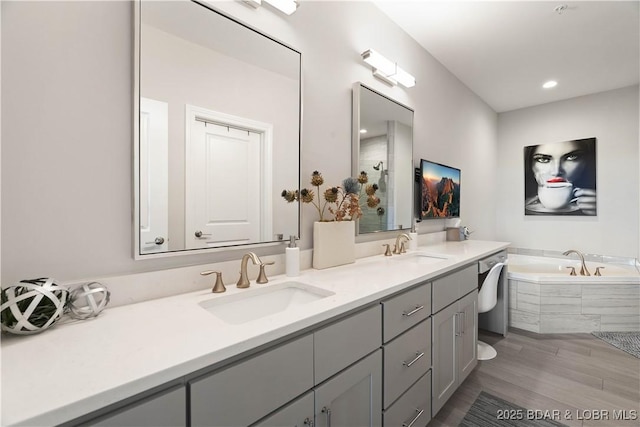 166 Captiva Dr Unit 5D, Sunrise Beach, MO 65079 - bathroom with double vanity, a garden tub, wood finished floors, and a tile shower