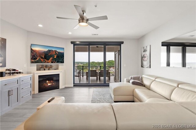 166 Captiva Dr Unit 5D, Sunrise Beach, MO 65079 - living area featuring ceiling fan, light wood finished floors, recessed lighting, and a glass covered fireplace