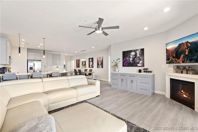 166 Captiva Dr Unit 5D, Sunrise Beach, MO 65079 - living area featuring light wood-style floors, a ceiling fan, recessed lighting, and a glass covered fireplace