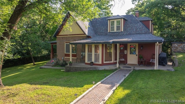 87 Outback Loop, Linn Creek, MO 65052 - view of front of home featuring a porch, a front lawn, a shingled roof, and a chimney