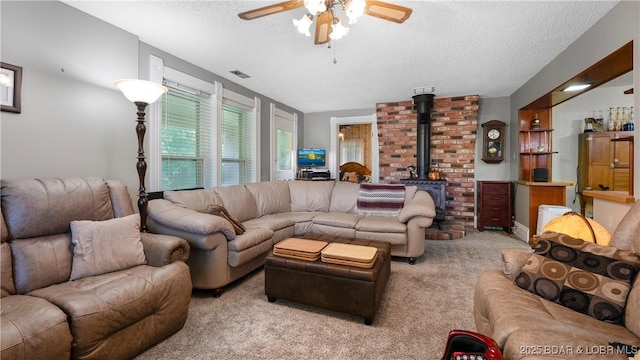 87 Outback Loop, Linn Creek, MO 65052 - living area with a textured ceiling, a wood stove, carpet flooring, and ceiling fan