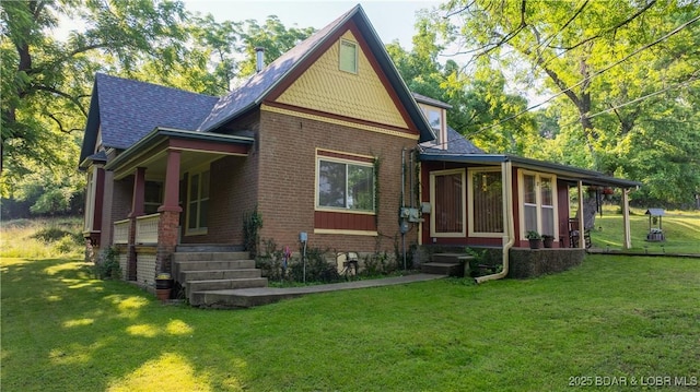 87 Outback Loop, Linn Creek, MO 65052 - view of front facade with a porch, a front yard, brick siding, a sunroom, and roof with shingles