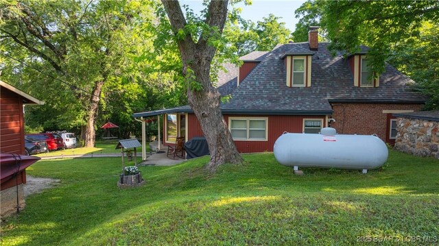 87 Outback Loop, Linn Creek, MO 65052 - rear view of house featuring a chimney, roof with shingles, a lawn, and a patio area
