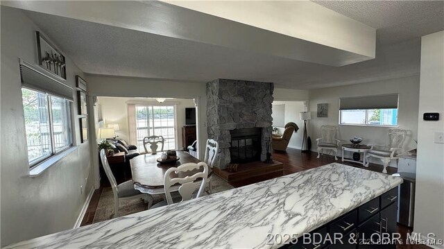 28136 Lyndsey Ln, Rocky Mount, MO 65072 - kitchen featuring open floor plan, dark wood finished floors, healthy amount of natural light, a fireplace, and a textured ceiling