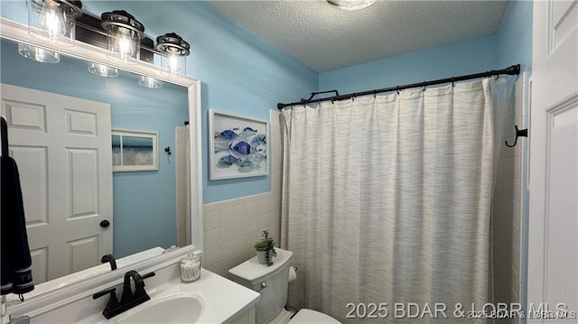 28136 Lyndsey Ln, Rocky Mount, MO 65072 - full bathroom with a textured ceiling, vanity, tile walls, a shower with shower curtain, and wainscoting