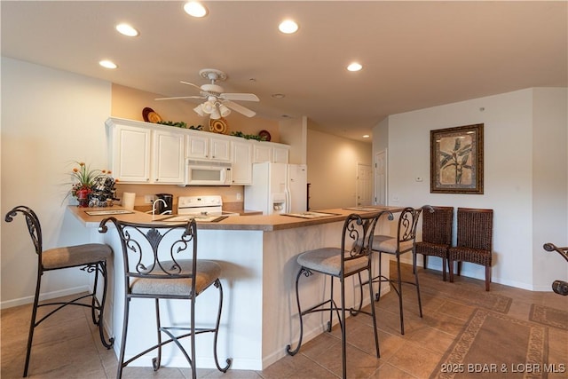 440 Cedar Heights Dr Unit 1C, Camdenton, MO 65020 - kitchen with white appliances, recessed lighting, a kitchen breakfast bar, ceiling fan, and a peninsula