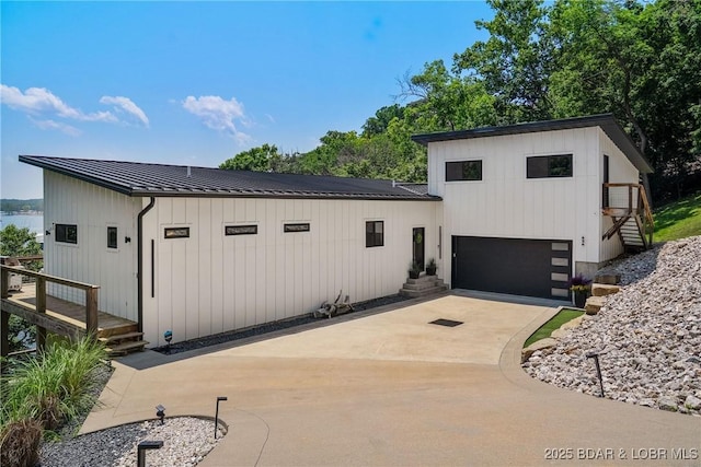 626 Eagle Dr, Four Seasons, MO 65049 - view of front of house with driveway, a standing seam roof, a metal roof, and a garage