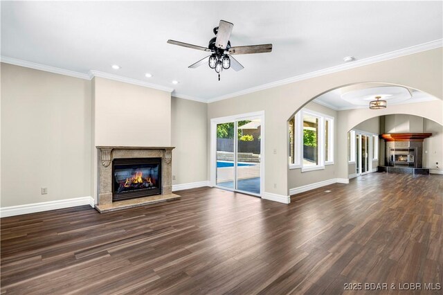 82 Fawn Meadows Dr, Linn Creek, MO 65052 - unfurnished living room with a glass covered fireplace, a ceiling fan, dark wood-type flooring, arched walkways, and recessed lighting