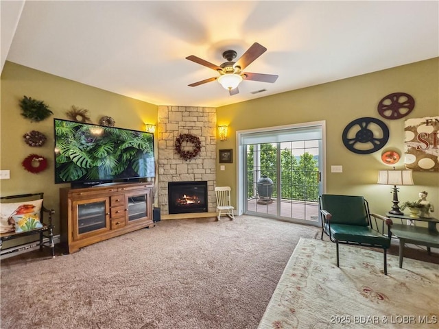 172 Highland Pkwy, Camdenton, MO 65020 - living room featuring a stone fireplace, carpet floors, and a ceiling fan