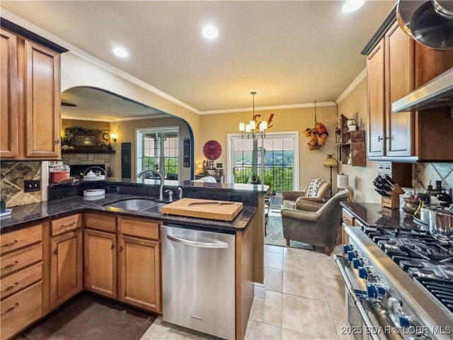 172 Highland Pkwy, Camdenton, MO 65020 - kitchen with stainless steel appliances, arched walkways, brown cabinetry, tasteful backsplash, and ornamental molding