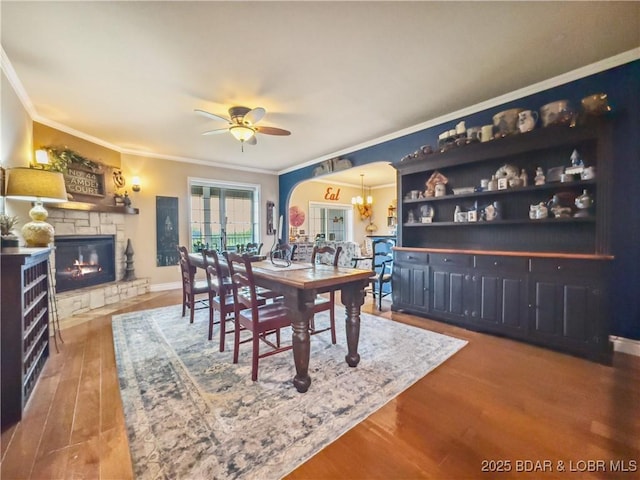 172 Highland Pkwy, Camdenton, MO 65020 - dining area with ornamental molding, wood finished floors, ceiling fan, a fireplace, and a chandelier