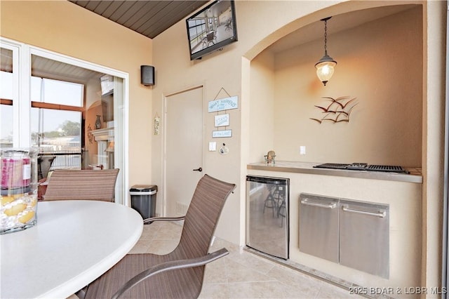 1184 Jeffries Rd Unit 113, Osage Beach, MO 65065 - dining room featuring arched walkways, bar area, beverage cooler, light tile patterned floors, and vaulted ceiling