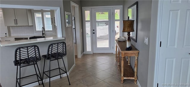30141 Gentle Cv, Gravois Mills, MO 65037 - kitchen featuring a breakfast bar, light countertops, light tile patterned flooring, backsplash, and plenty of natural light