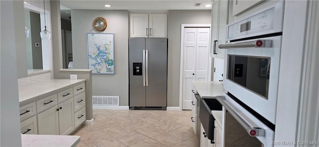 30141 Gentle Cv, Gravois Mills, MO 65037 - kitchen with stainless steel fridge, white cabinetry, recessed lighting, double oven, and light stone counters