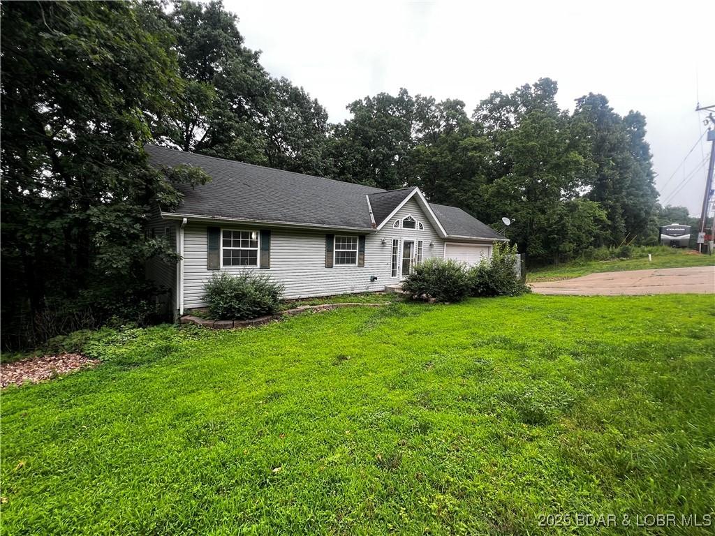 1509 Oak Bend Rd, Sunrise Beach, MO 65079 - view of front of home featuring a front lawn and an attached garage