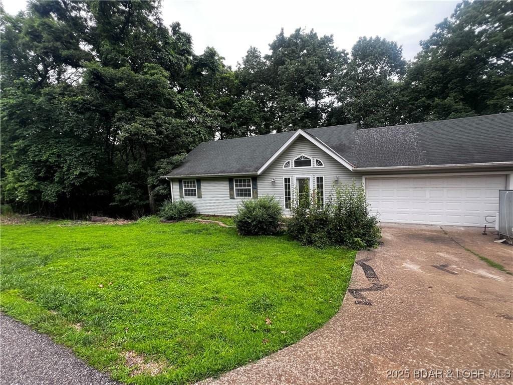 1509 Oak Bend Rd, Sunrise Beach, MO 65079 - single story home featuring driveway, a garage, a front yard, and roof with shingles