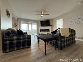 320 Regatta Bay Cir Unit 3B, Lake Ozark, MO 65049 - living room with a ceiling fan, wood finished floors, and a glass covered fireplace