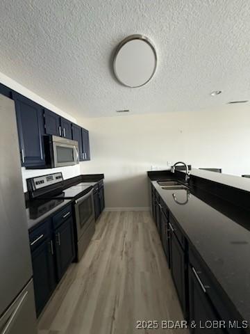 320 Regatta Bay Cir Unit 3B, Lake Ozark, MO 65049 - kitchen with stainless steel appliances, a textured ceiling, and light wood finished floors