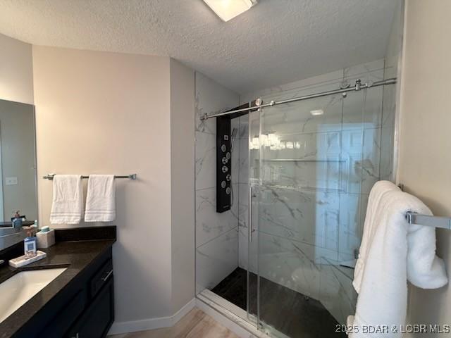 320 Regatta Bay Cir Unit 3B, Lake Ozark, MO 65049 - bathroom featuring vanity, a marble finish shower, and a textured ceiling