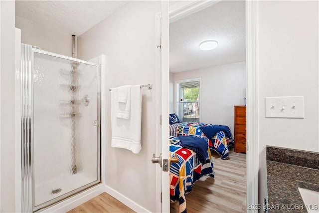 320 Regatta Bay Cir Unit 3B, Lake Ozark, MO 65049 - ensuite bathroom featuring wood finished floors, a stall shower, and vanity